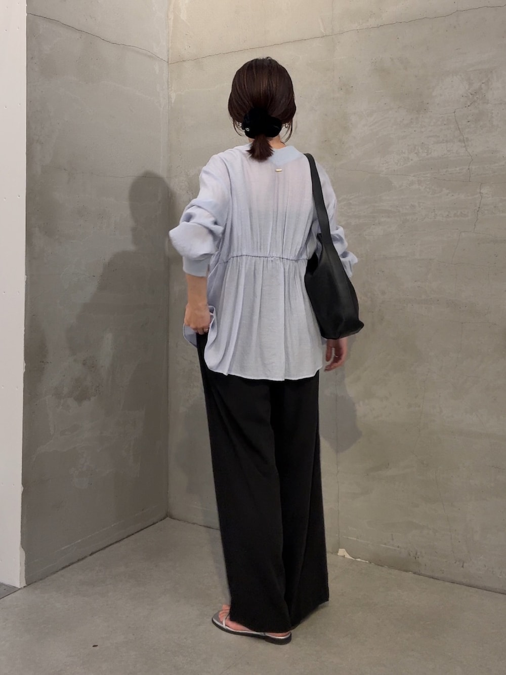 ブルー系のシャツ/ブラウス、ブラック系のスラックスを着用したレディースの冬コーディネートの2枚目の写真