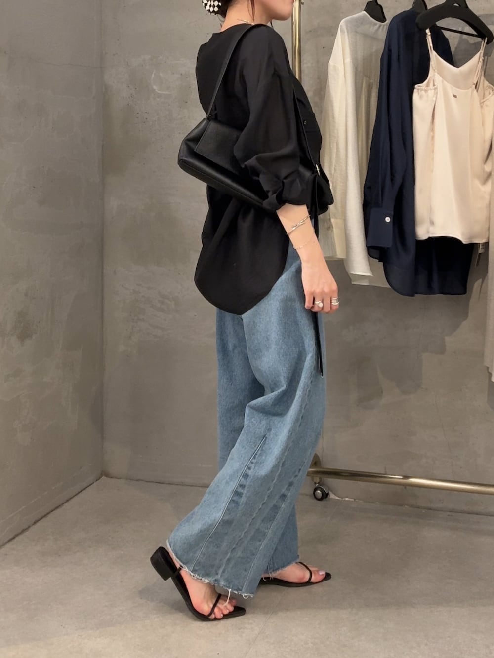 ブラック系のシャツ/ブラウス、ブルー系のデニムパンツ、ブラック系のバッグを着用したレディースの冬コーディネートの3枚目の写真