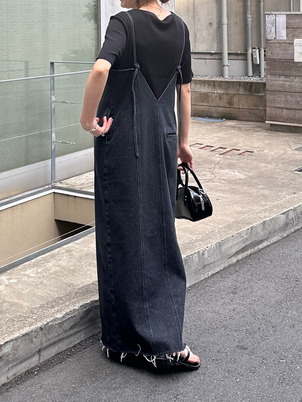 ブルー系のワンピース、ブラック系のTシャツ/カットソー、ブラック系のバッグを着用したレディースの夏コーディネートの2枚目の写真