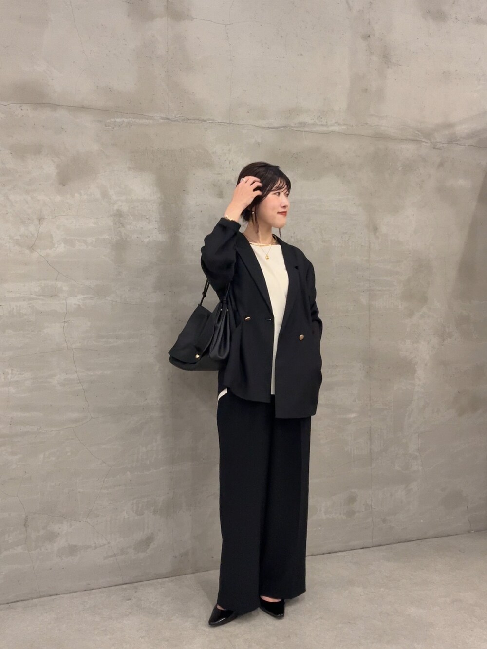 ブラック系のテーラードジャケット、ブラック系のその他パンツ、ホワイト系のシャツ/ブラウスを着用したレディースの春コーディネートの2枚目の写真