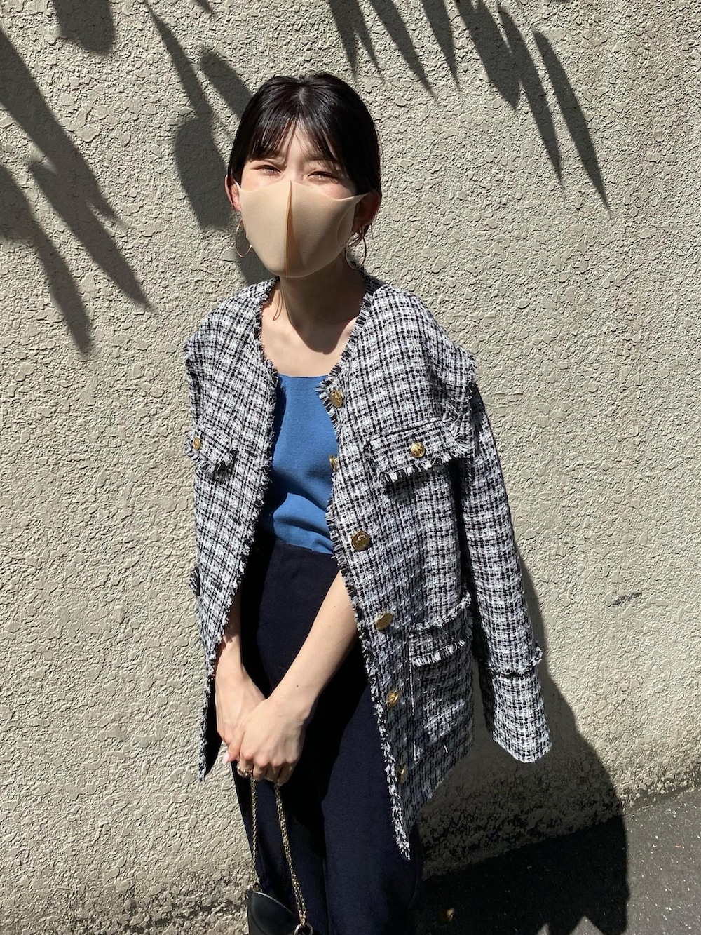 ブルー系のスラックス、ブラック系のノーカラージャケット、ブルー系のタンクトップを着用したレディースの秋コーディネートの4枚目の写真