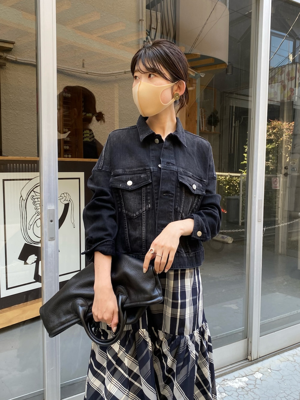 ブラック系のトートバッグ、ブラック系のスカート、ブラック系のデニムジャケットを着用したレディースの秋コーディネートの3枚目の写真