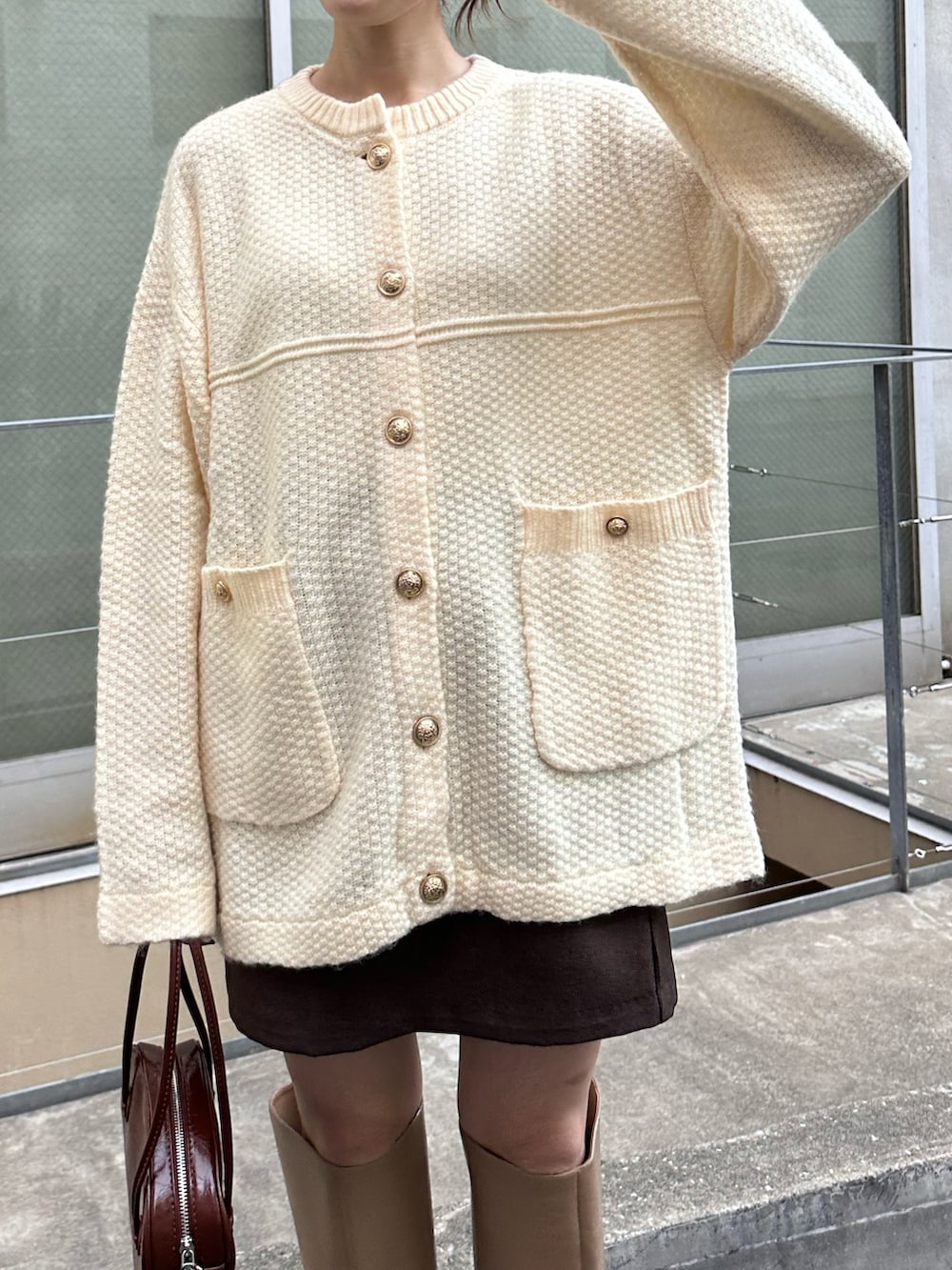 ホワイト系のカーディガン/ボレロ、ブラウン系のスカート、ベージュ系のブーツを着用したレディースの秋コーディネートの3枚目の写真