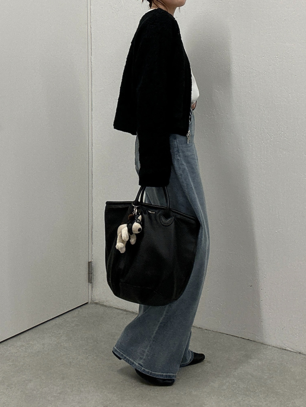 ブラック系のカーディガン/ボレロ、ブルー系のデニムパンツ、ホワイト系のシャツ/ブラウスを着用したレディースの冬コーディネートの2枚目の写真