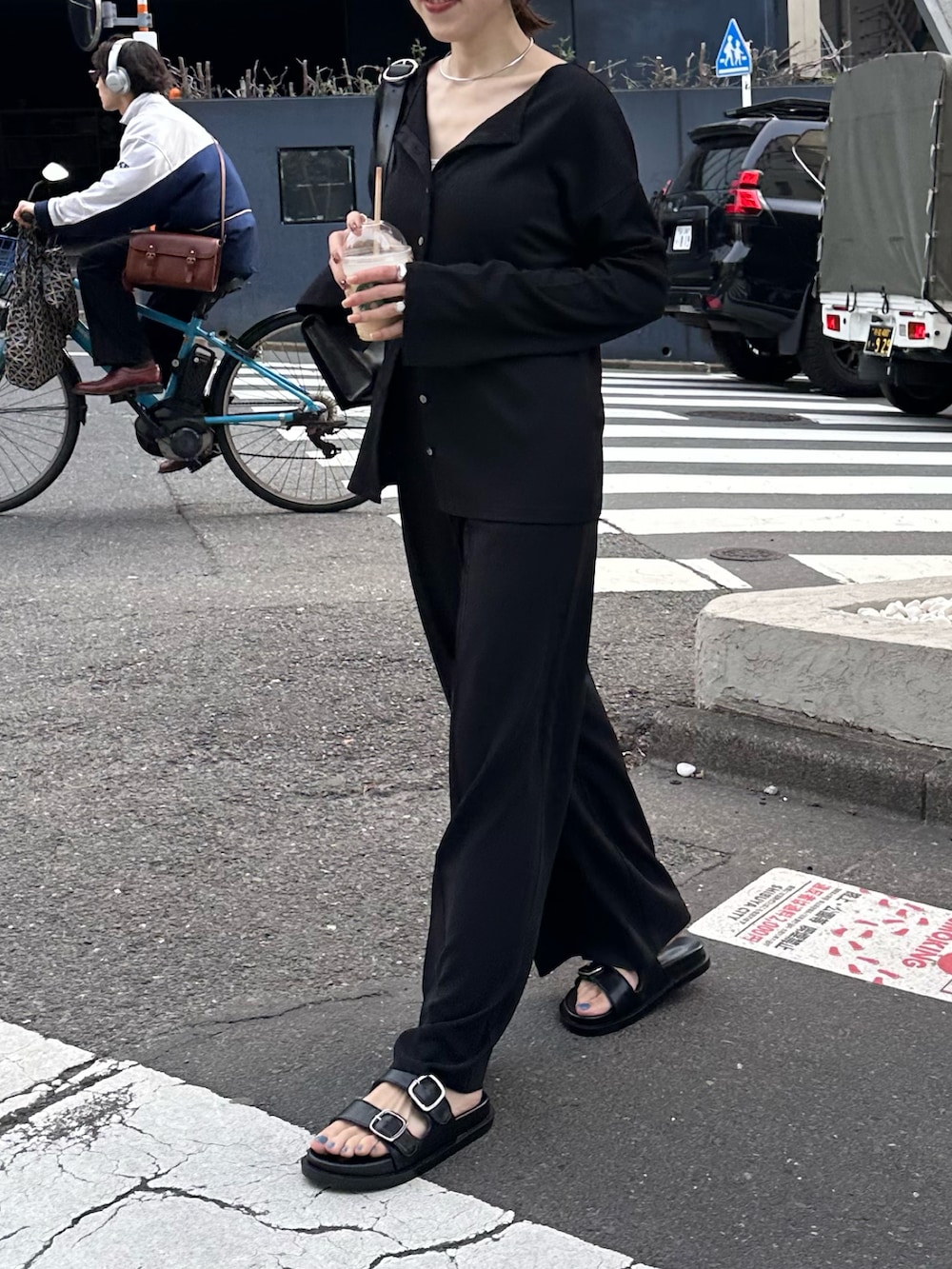 ブラック系のシャツ/ブラウス、ブラック系のスラックス、ブラック系のサンダルを着用したレディースの春コーディネートの2枚目の写真