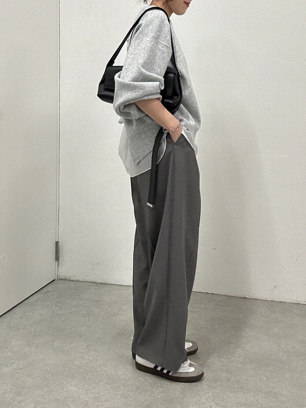 グレー系のニット/セーター、ホワイト系のTシャツ/カットソー、グレー系のその他パンツを着用したレディースの冬コーディネートの4枚目の写真