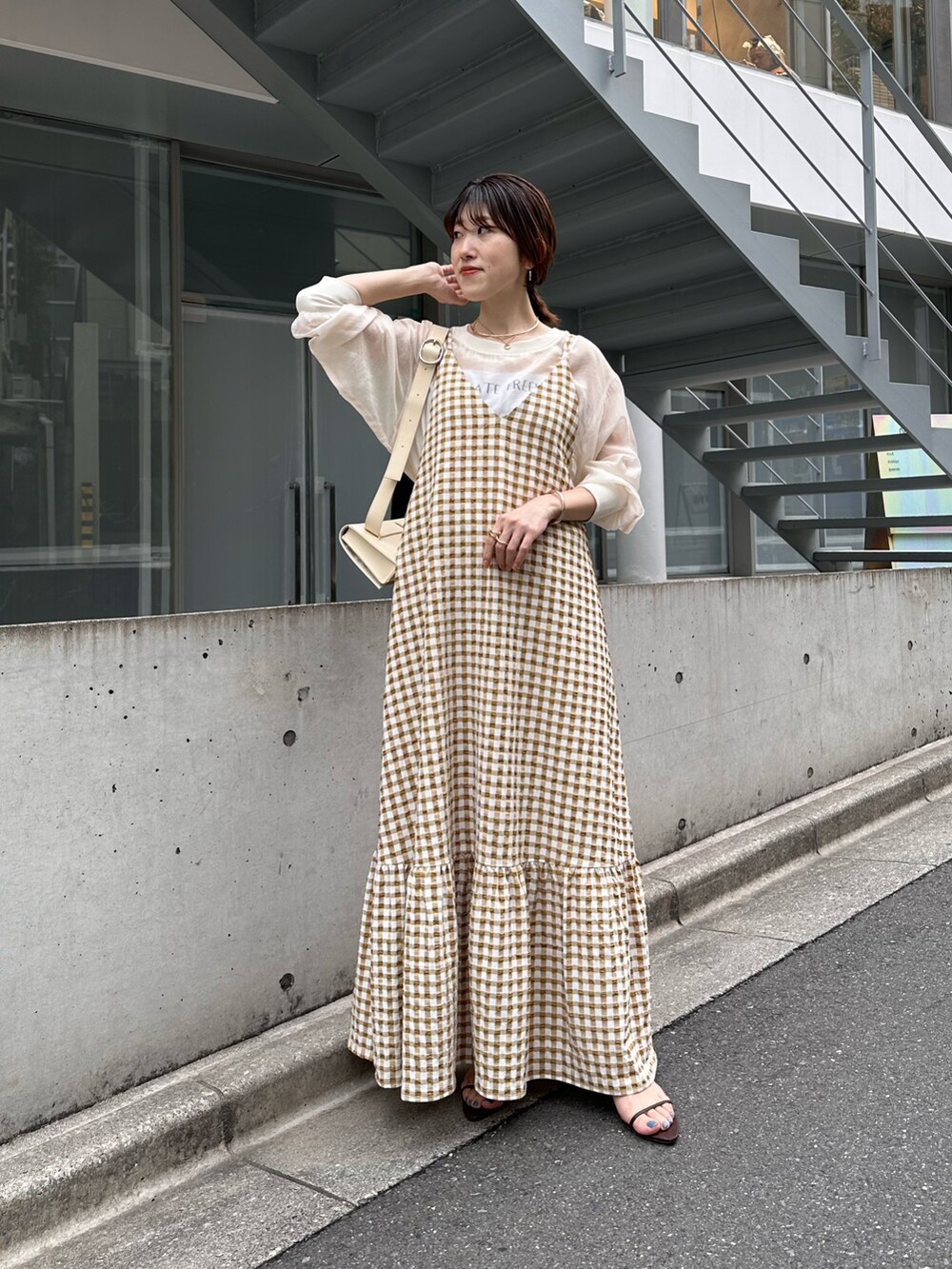 ベージュ系のワンピース、ホワイト系のTシャツ/カットソー、ブラック系のシューズを着用したレディースの春コーディネートの3枚目の写真