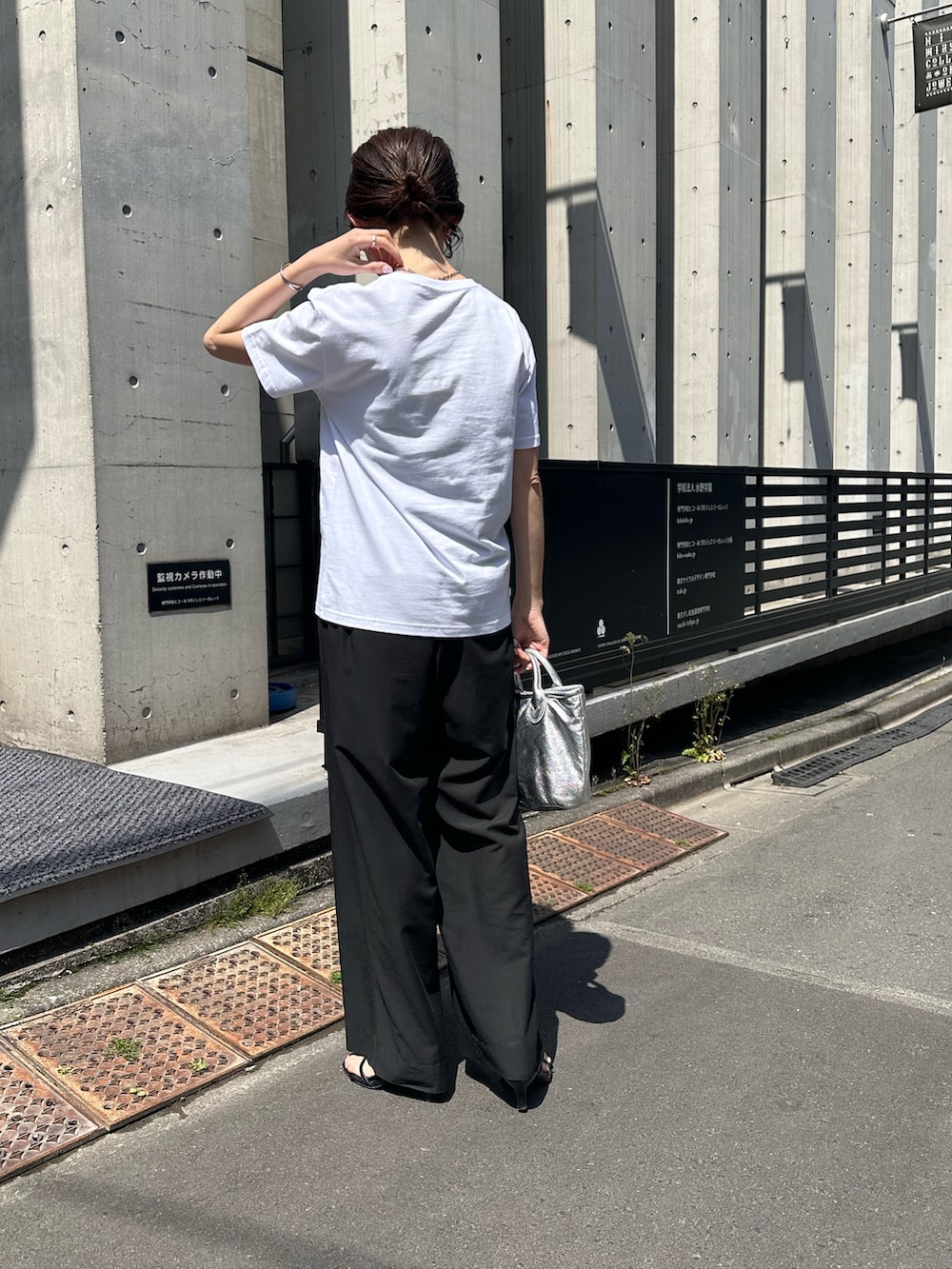 ホワイト系のTシャツ/カットソー、ブラック系のその他パンツ、シルバー系のトートバッグを着用したレディースの春コーディネートの2枚目の写真