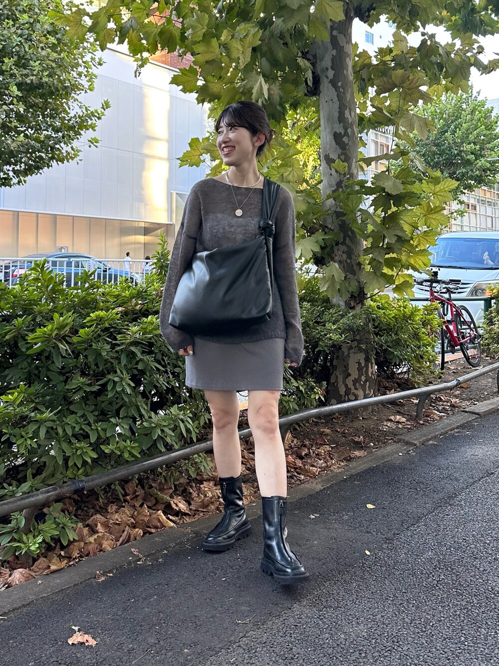 ブラック系のブーツ、ブルー系のニット/セーター、グレー系のスカートを着用したレディースの秋コーディネートの3枚目の写真