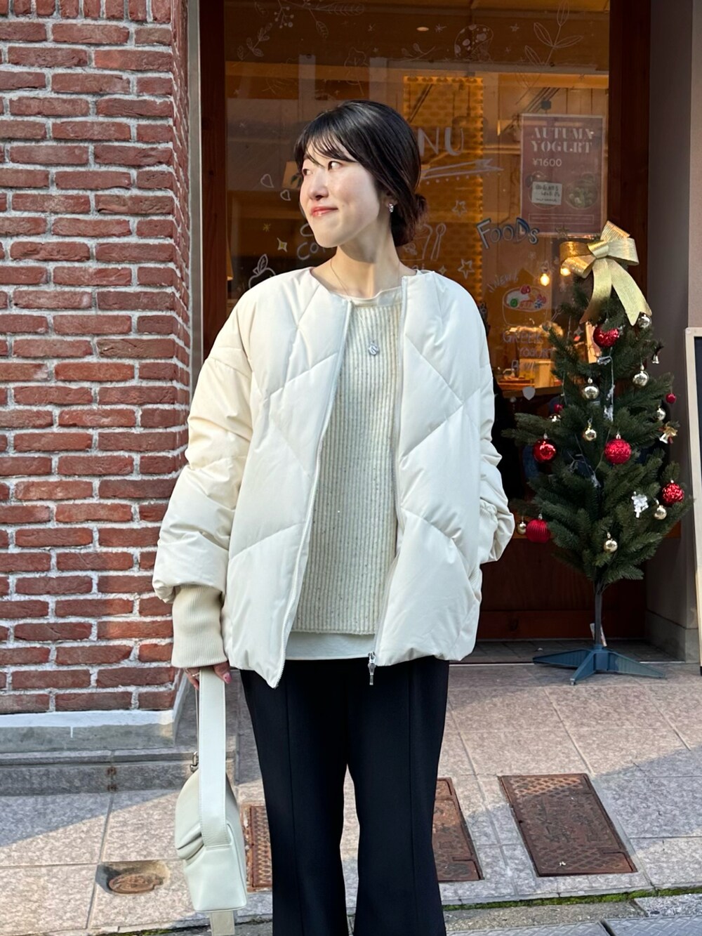 ホワイト系のニット/セーター、ブルー系のスラックス、ホワイト系のシャツ/ブラウスを着用したレディースの冬コーディネートの3枚目の写真