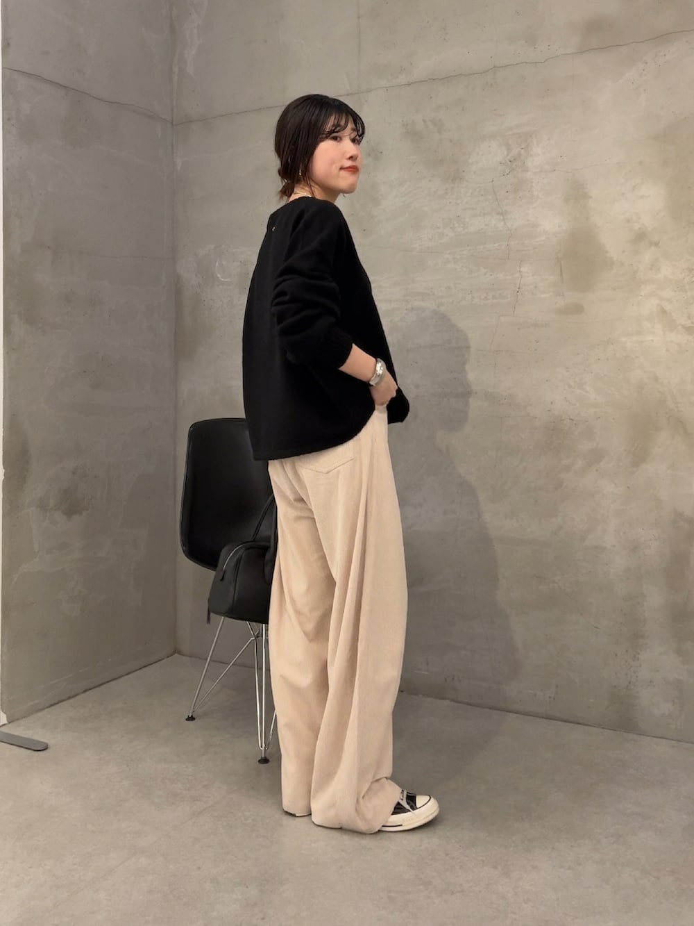 ブラック系のニット/セーター、ホワイト系のデニムパンツを着用したレディースの冬コーディネートの4枚目の写真