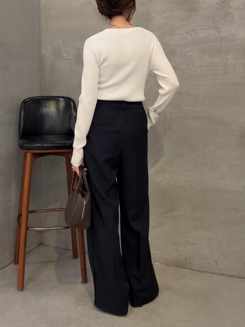 ホワイト系のニット/セーター、ブラウン系のショルダーバッグ、ブルー系のスラックスを着用したレディースの夏コーディネートの3枚目の写真