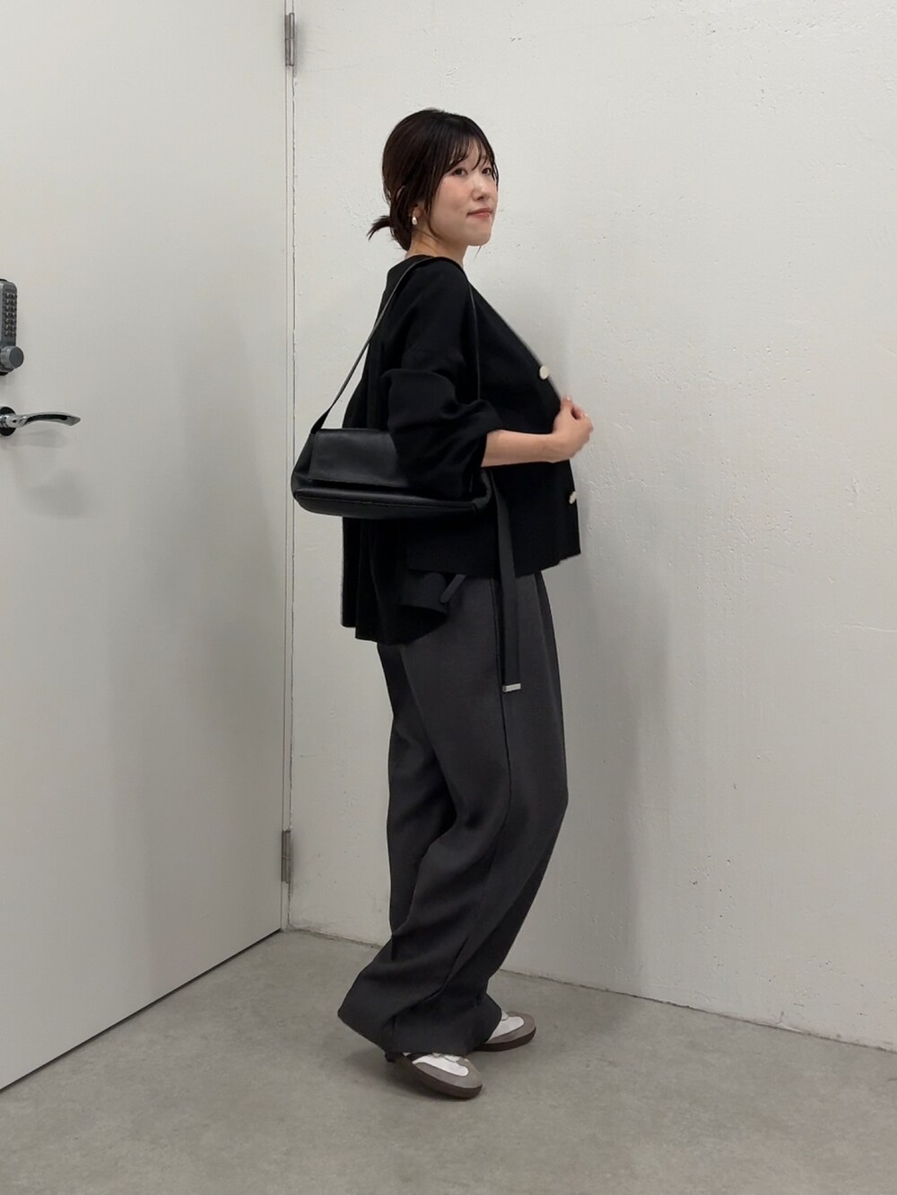 ブラック系のカーディガン/ボレロ、ホワイト系のTシャツ/カットソー、グレー系のスラックスを着用したレディースの秋コーディネートの4枚目の写真