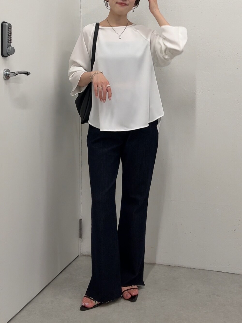 ホワイト系のシャツ/ブラウス、ブルー系のデニムパンツ、ブラック系のショルダーバッグを着用したレディースの夏コーディネートの4枚目の写真