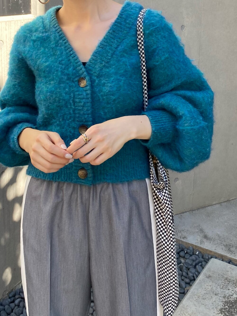 ブルー系のカーディガン/ボレロ、グレー系のスラックスを着用したレディースの秋コーディネートの5枚目の写真