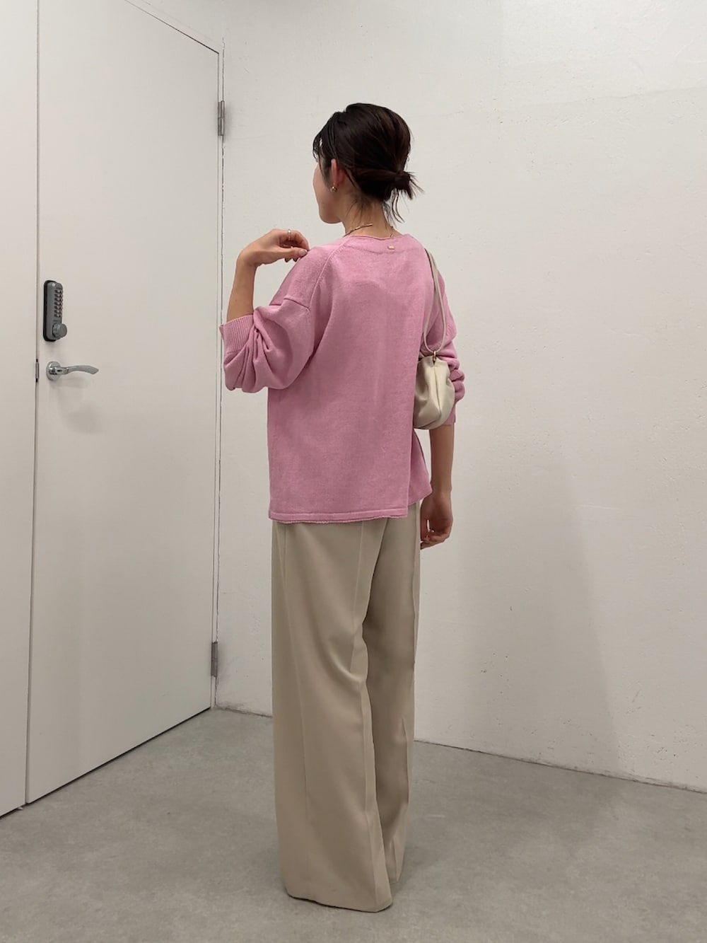 ピンク系のカーディガン/ボレロ、ベージュ系のスラックス、ホワイト系のタンクトップを着用したレディースの春コーディネートの4枚目の写真