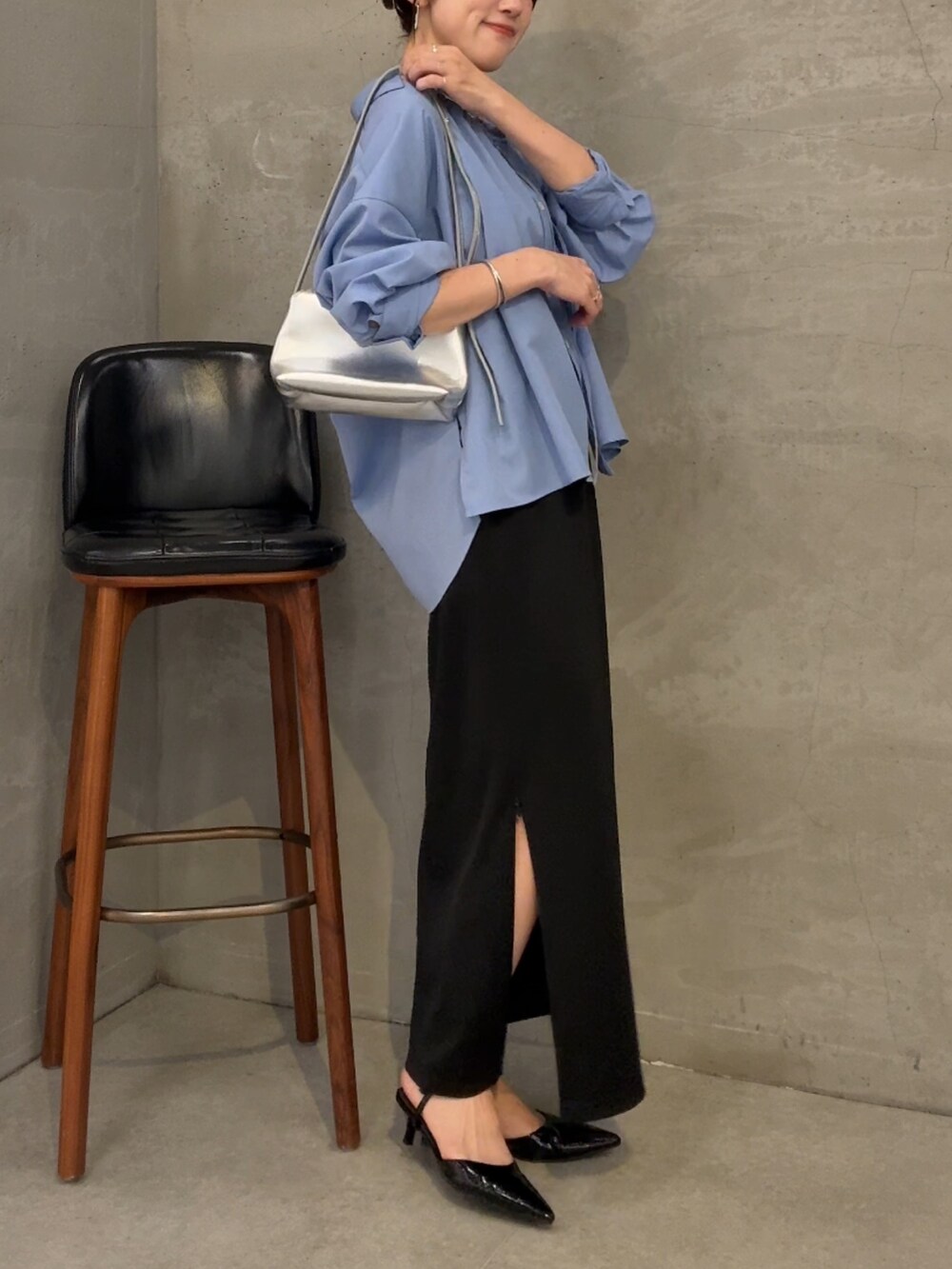 ブラック系のスカート、ブルー系のシャツ/ブラウス、シルバー系のショルダーバッグを着用したレディースの夏コーディネートの3枚目の写真