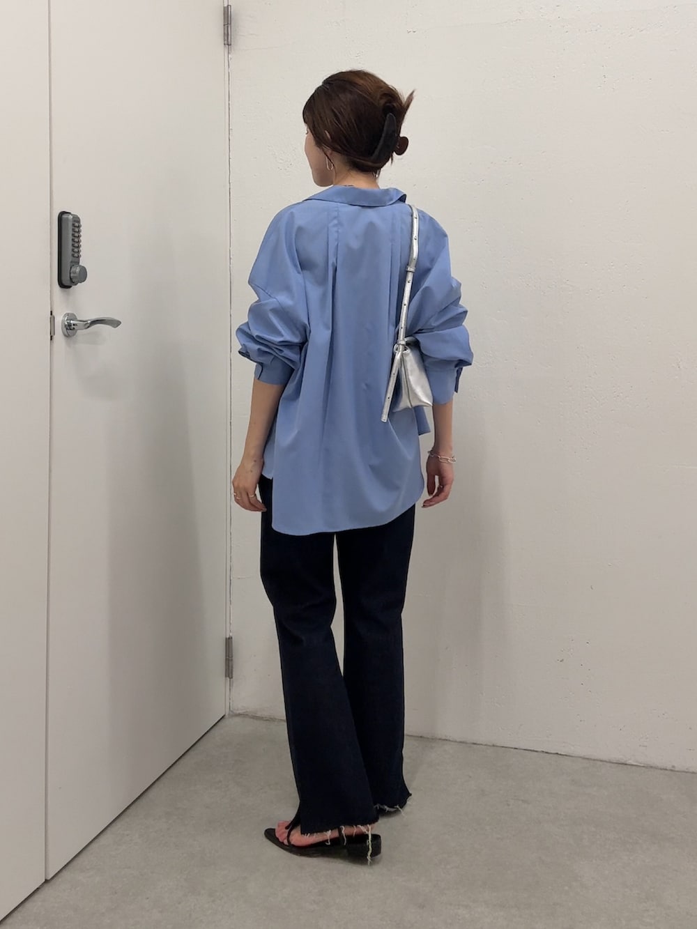 ブルー系のシャツ/ブラウス、ブルー系のデニムパンツ、シルバー系のショルダーバッグを着用したレディースの夏コーディネートの2枚目の写真