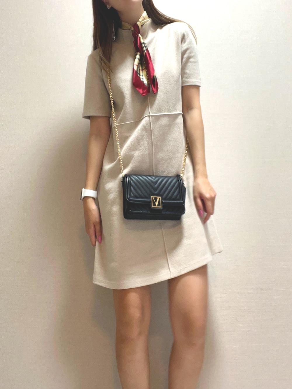 ベージュ系のワンピース、ブラック系のショルダーバッグ、ホワイト系のスニーカーを着用したレディースの春コーディネートの2枚目の写真