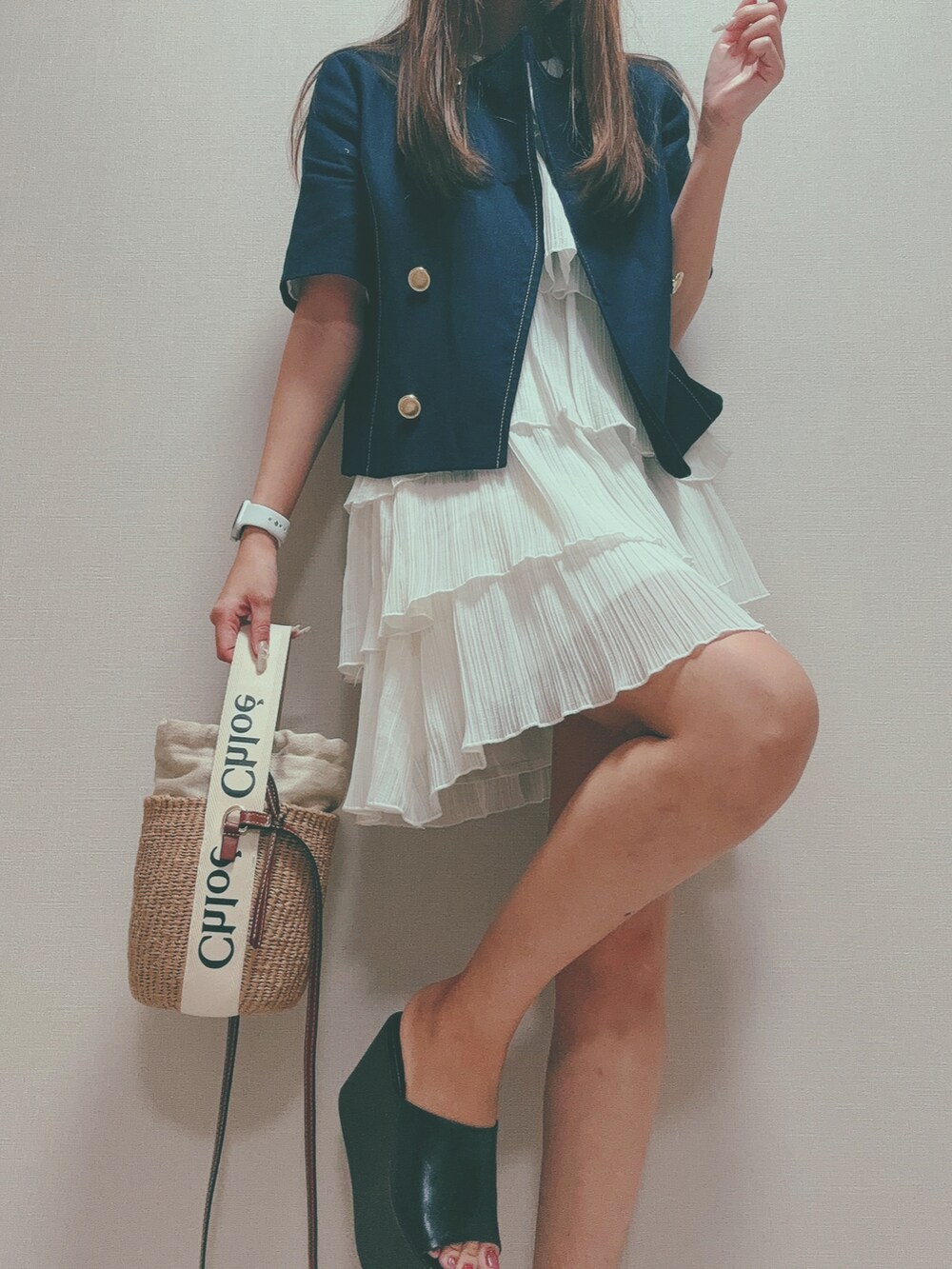 ベージュ系のショルダーバッグ、ブルー系のノーカラージャケット、ホワイト系のワンピースを着用したレディースの秋コーディネートの3枚目の写真