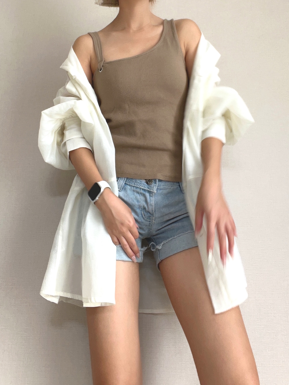 ブラウン系のタンクトップ、ブルー系のデニムパンツ、ベージュ系のシャツ/ブラウスを着用したレディースの冬コーディネートの3枚目の写真
