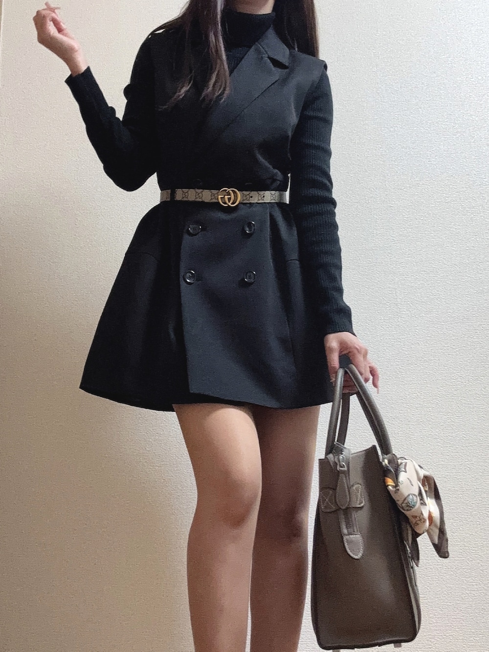 ブラック系のニット/セーター、ブラック系のワンピース、ベージュ系のショルダーバッグを着用したレディースの秋コーディネートの3枚目の写真