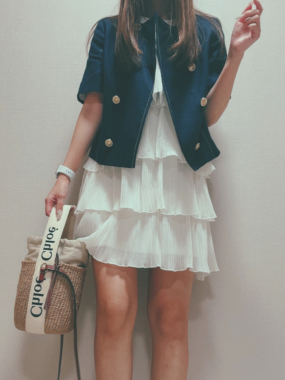 ベージュ系のショルダーバッグ、ブルー系のノーカラージャケット、ホワイト系のワンピースを着用したレディースの秋コーディネートの2枚目の写真