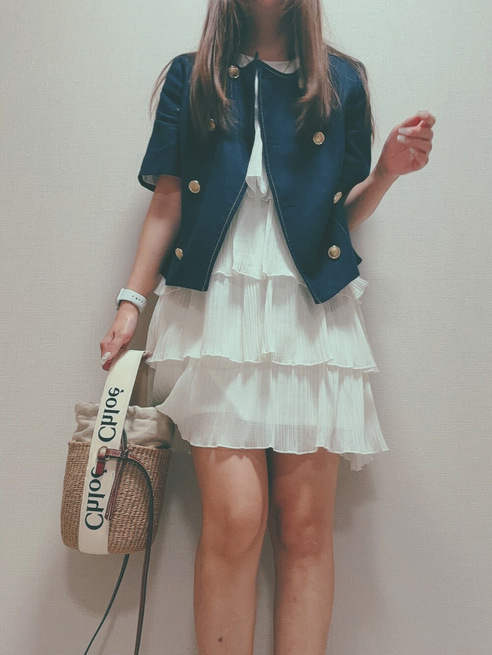 ベージュ系のショルダーバッグ、ブルー系のノーカラージャケット、ホワイト系のワンピースを着用したレディースの秋コーディネートの4枚目の写真