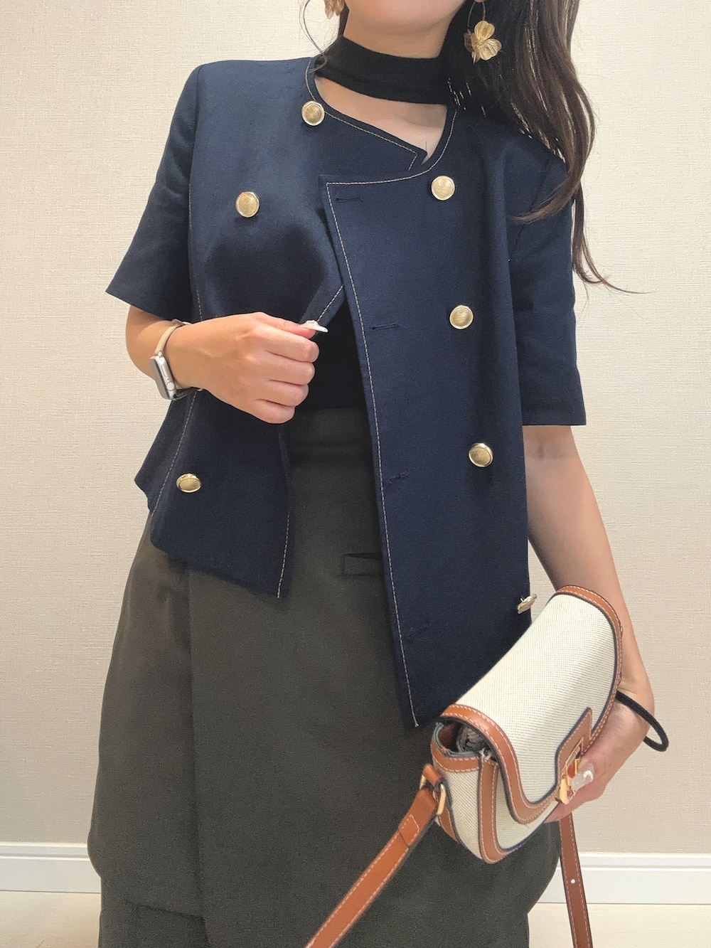 グリーン系のスラックス、ベージュ系のショルダーバッグ、ブルー系のノーカラージャケットを着用したレディースの夏コーディネートの3枚目の写真