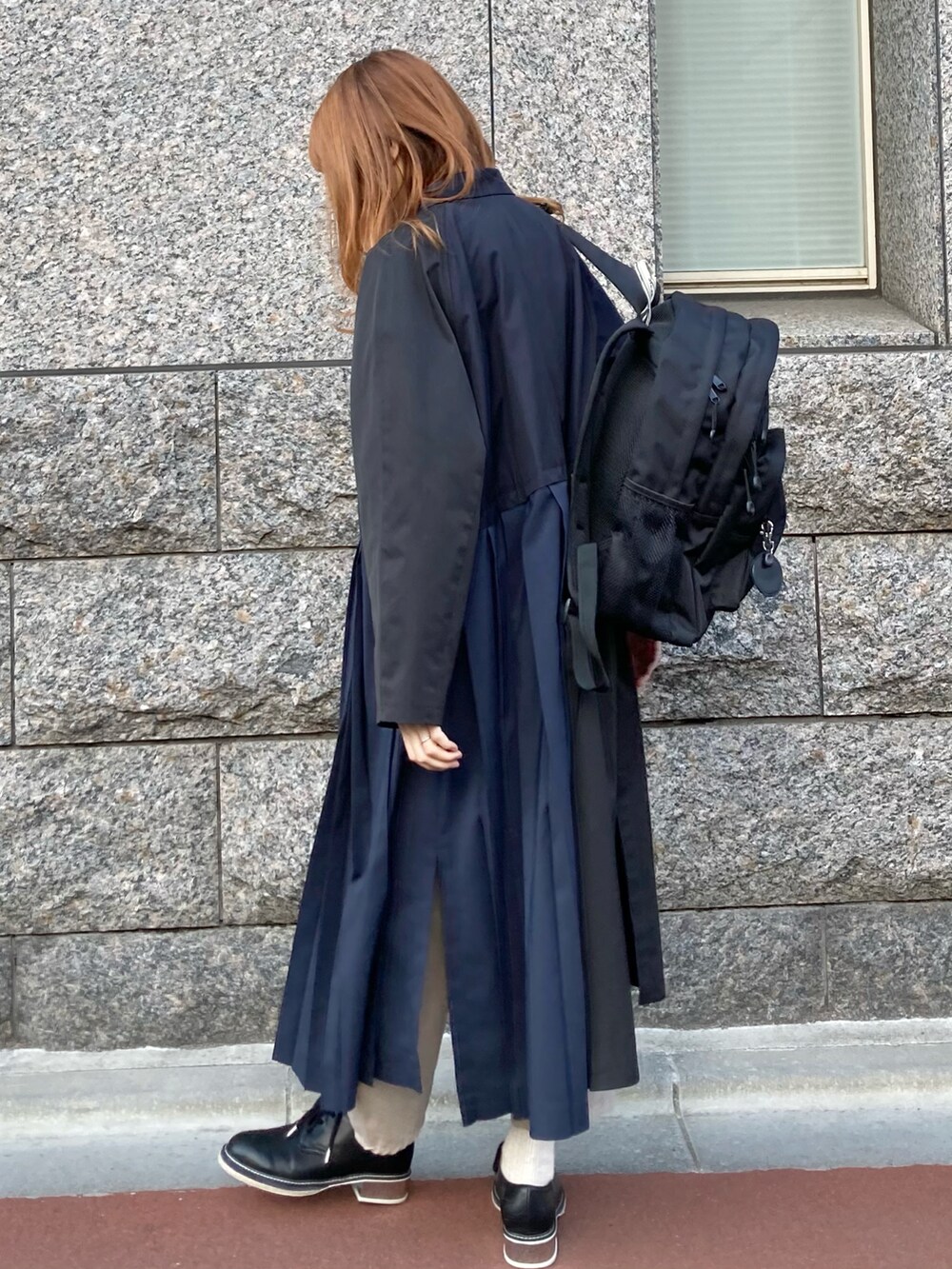 ブルー系のステンカラーコート、ブラック系のバックパック/リュックを着用したレディースの春コーディネートの2枚目の写真