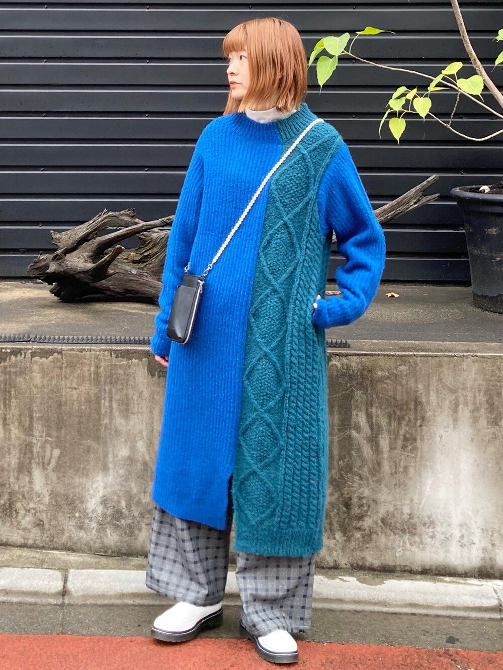 ブルー系のワンピース、ブラック系のショルダーバッグを着用したレディースの冬コーディネートの2枚目の写真