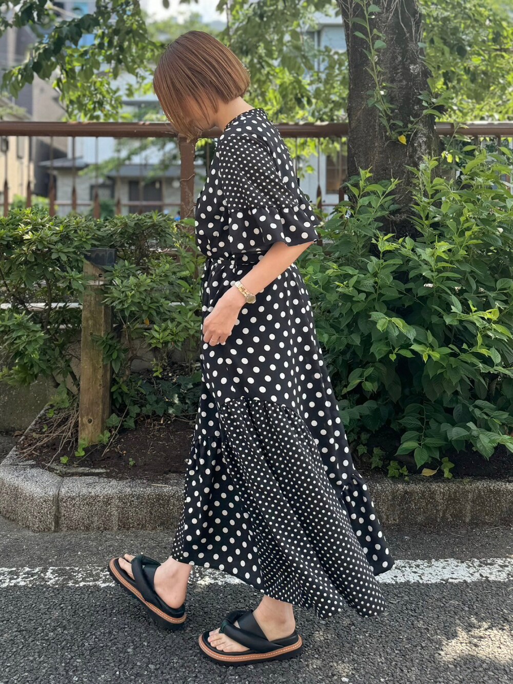 ブラック系のサンダル、ブラック系のワンピースを着用したレディースの夏コーディネートの2枚目の写真