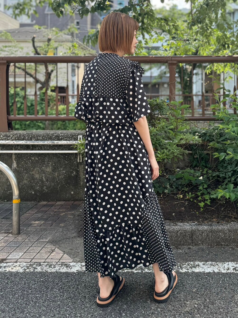 ブラック系のサンダル、ブラック系のワンピースを着用したレディースの夏コーディネートの3枚目の写真