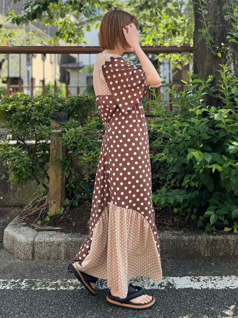 ブラック系のサンダル、ブラウン系のワンピースを着用したレディースの夏コーディネートの2枚目の写真