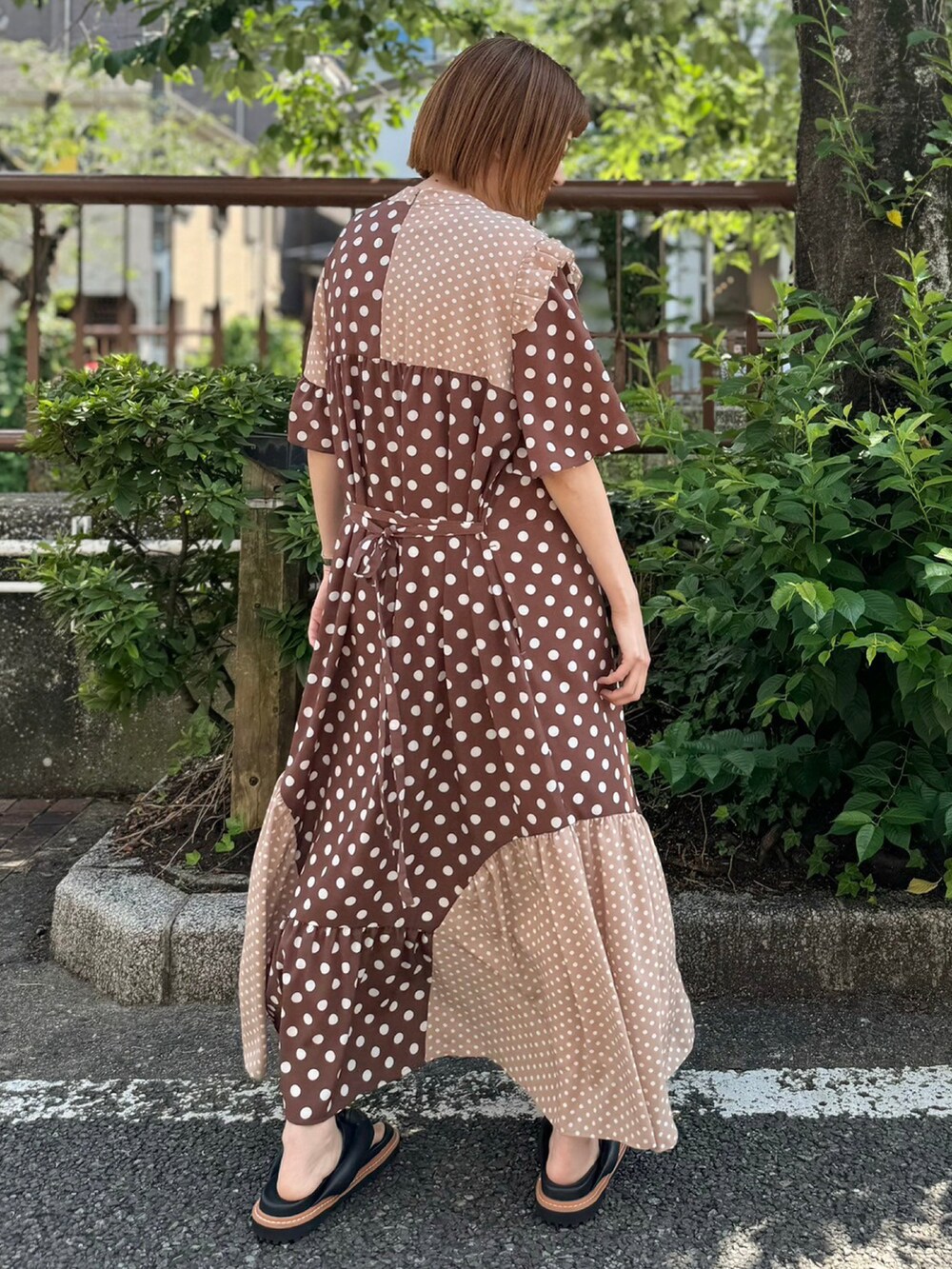 ブラック系のサンダル、ブラウン系のワンピースを着用したレディースの夏コーディネートの3枚目の写真