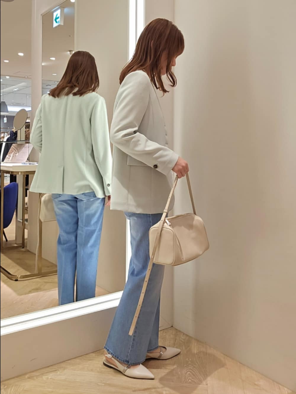 ブルー系のデニムパンツ、ホワイト系のカーディガン/ボレロ、グリーン系のノーカラージャケットを着用したレディースの冬コーディネートの5枚目の写真