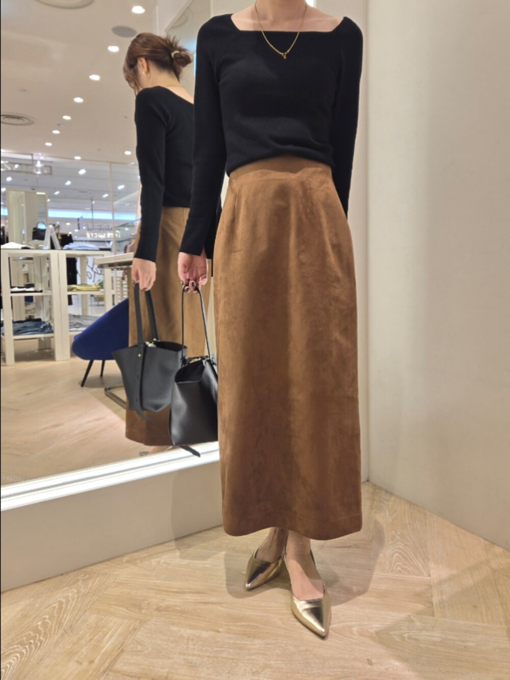 イエロー系のブルゾン、イエロー系のスカート、ベージュ系のショルダーバッグを着用したレディースの秋コーディネートの7枚目の写真