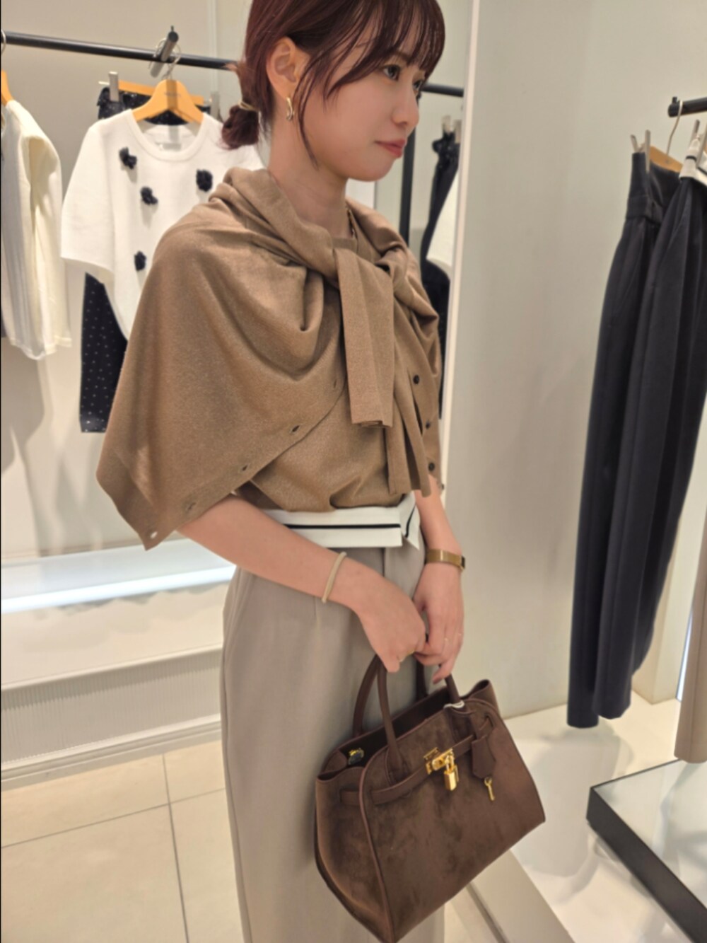 イエロー系のニット/セーター、イエロー系のカーディガン/ボレロ、グリーン系のスカートを着用したレディースの夏コーディネートの6枚目の写真