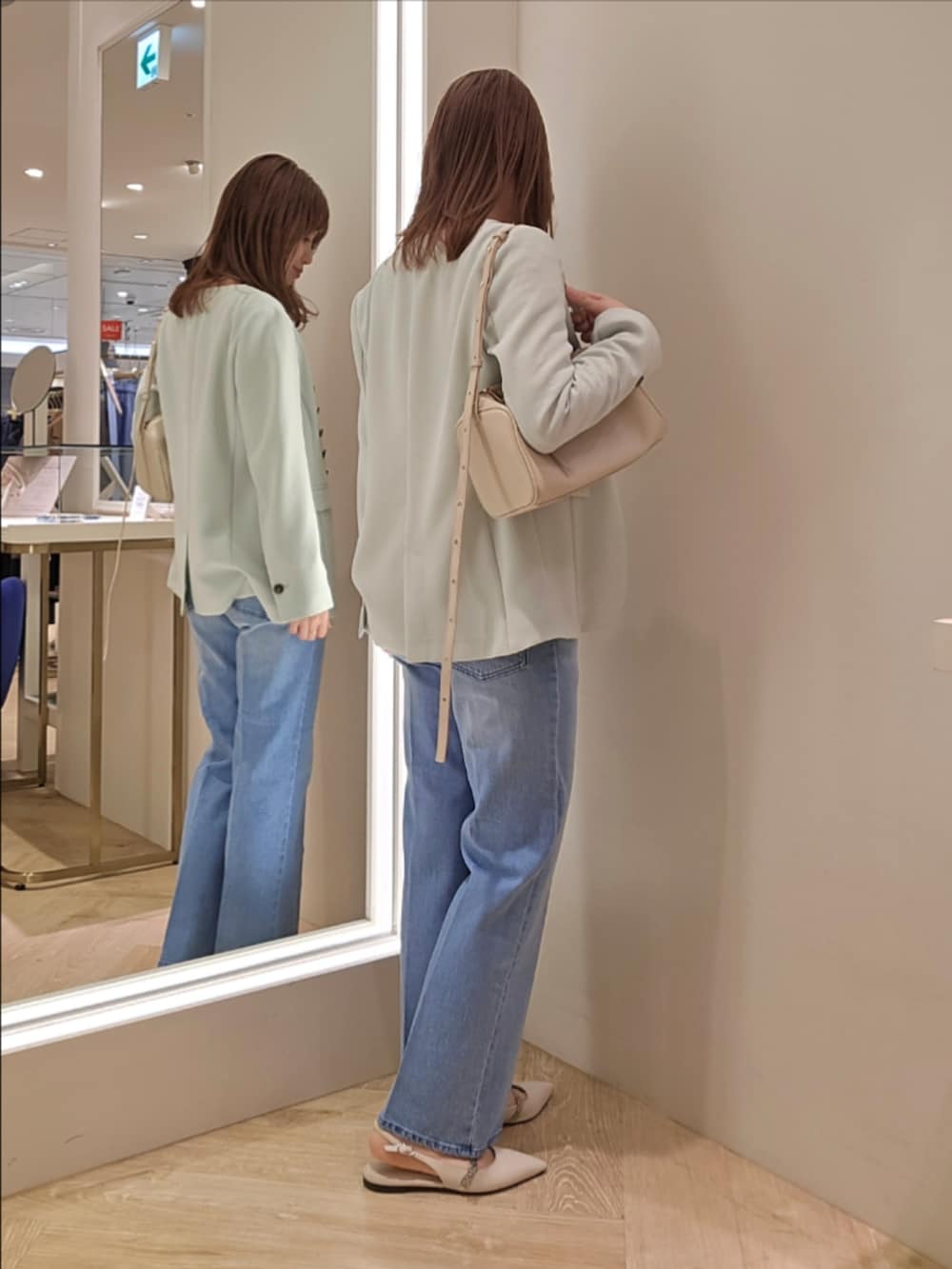 ブルー系のデニムパンツ、ホワイト系のカーディガン/ボレロ、グリーン系のノーカラージャケットを着用したレディースの冬コーディネートの3枚目の写真