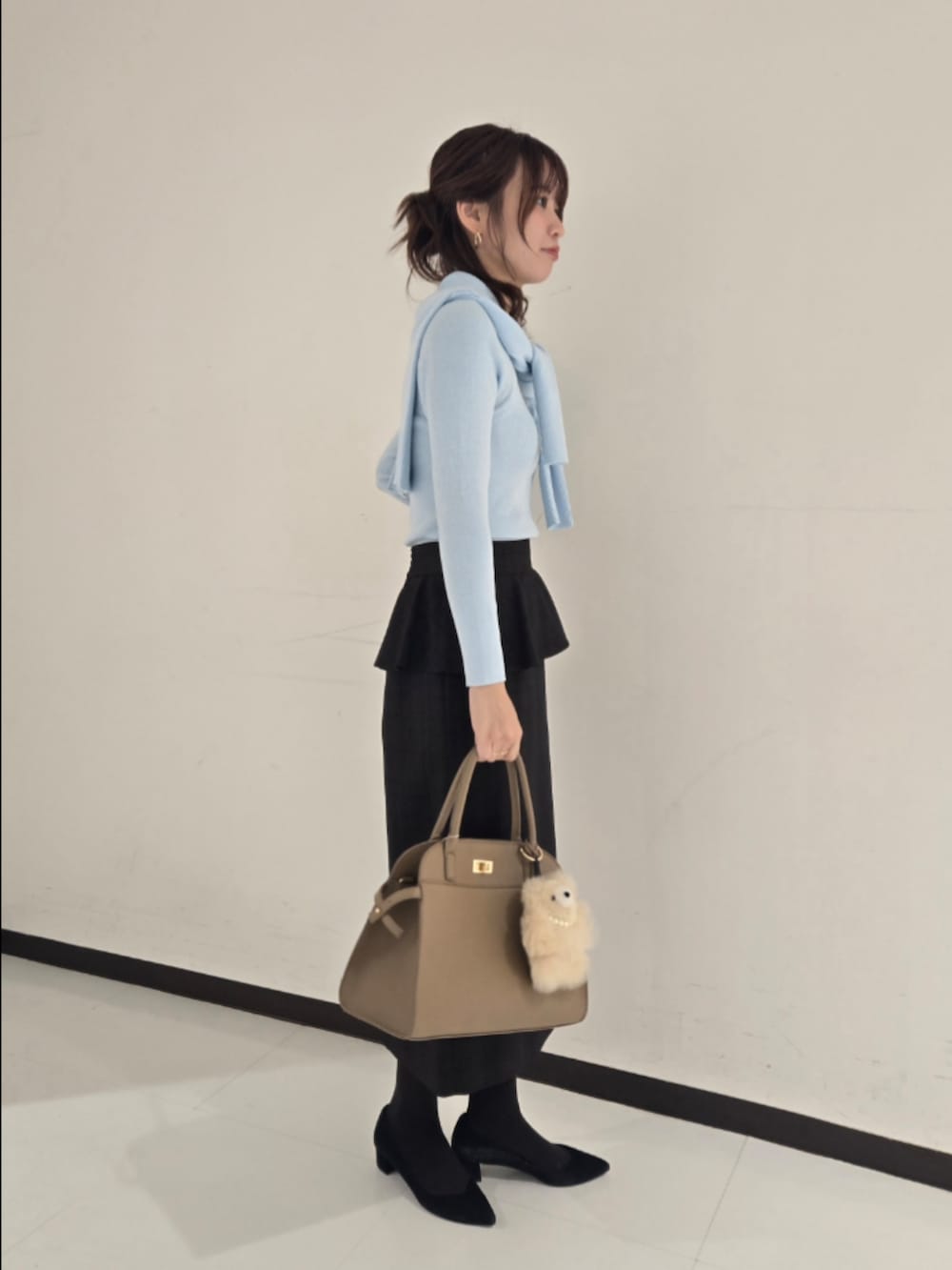 ブルー系のカーディガン/ボレロ、ブルー系のニット/セーター、ベージュ系のスカートを着用したレディースの秋コーディネートの2枚目の写真