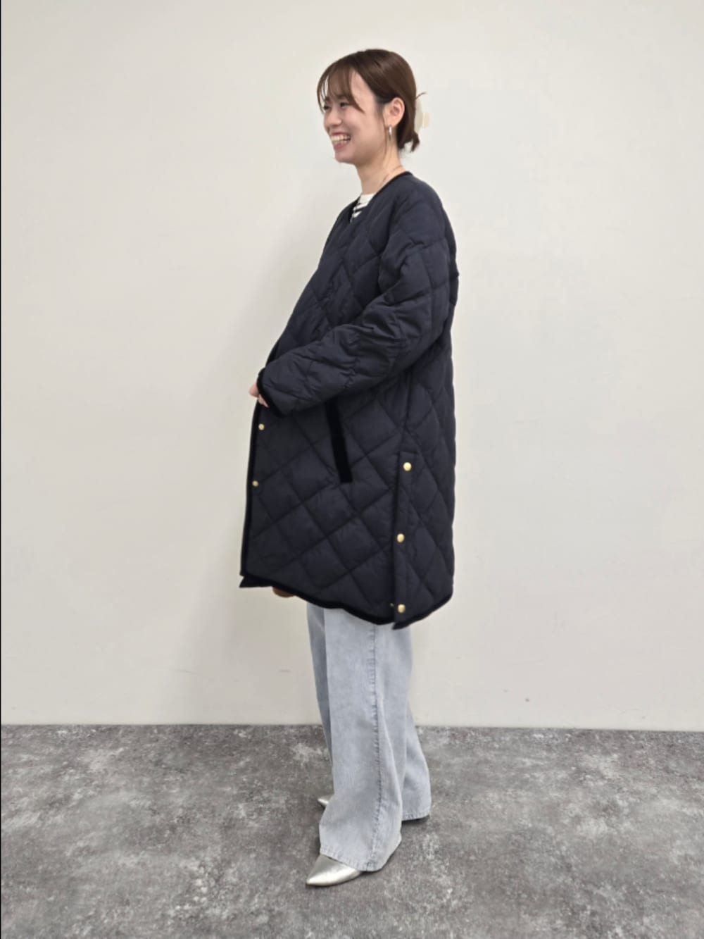 ブルー系のダウンジャケット/コート、ブラック系のTシャツ/カットソー、ブルー系のデニムパンツを着用したレディースの秋コーディネートの3枚目の写真