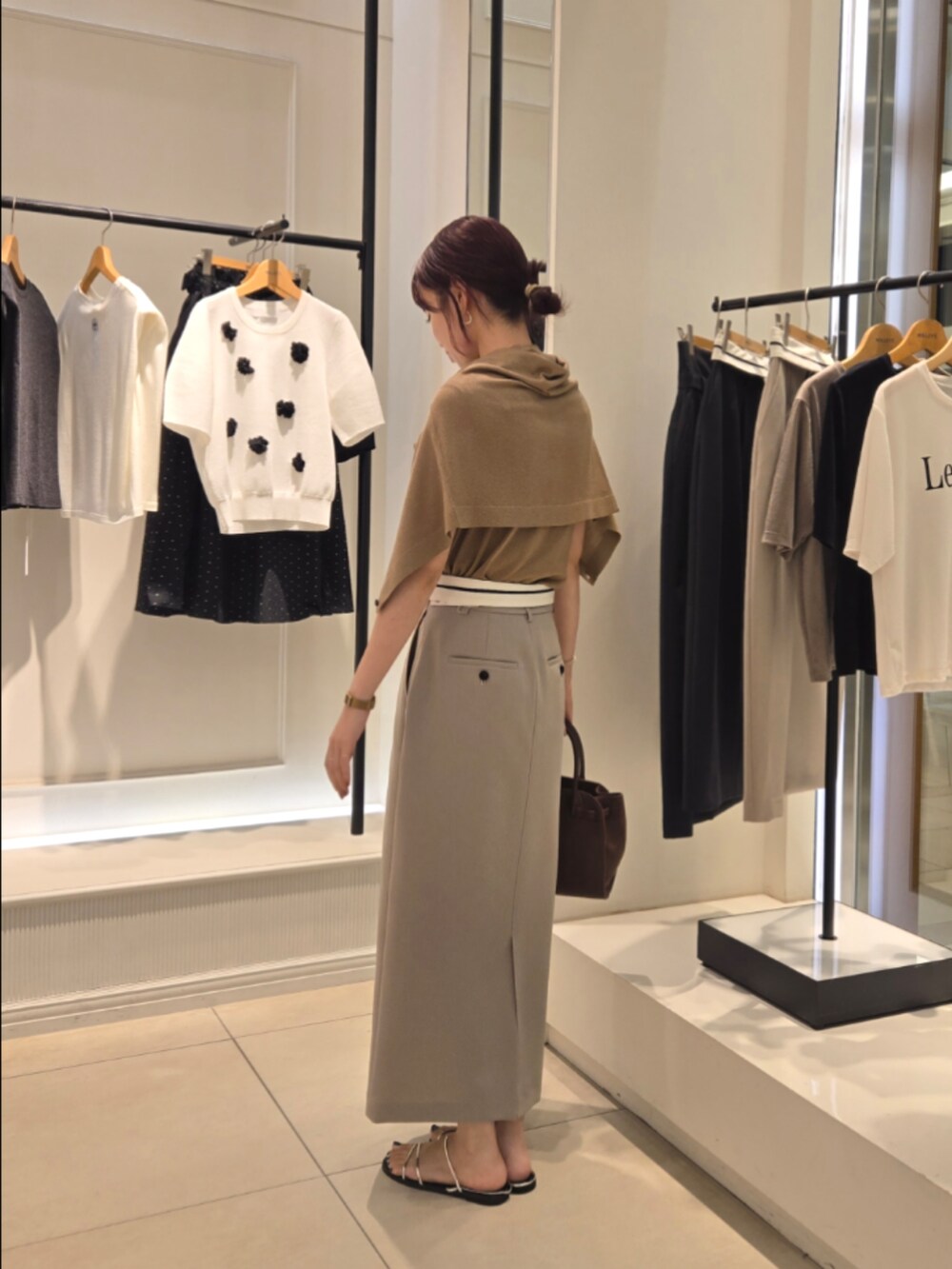 イエロー系のニット/セーター、イエロー系のカーディガン/ボレロ、グリーン系のスカートを着用したレディースの夏コーディネートの3枚目の写真