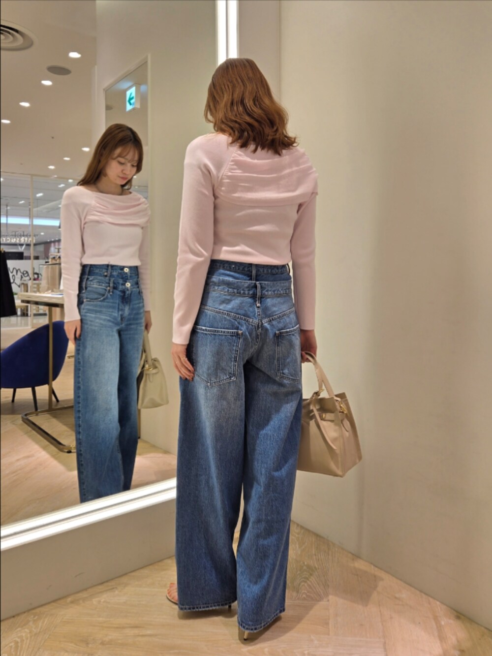 ピンク系のニット/セーター、ベージュ系のトートバッグ、グレー系のネックレスを着用したレディースの春コーディネートの2枚目の写真