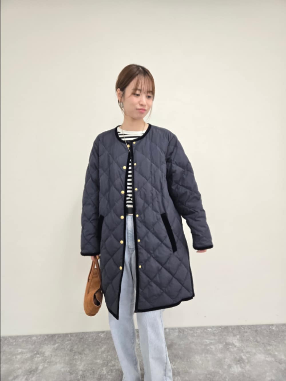 ブルー系のダウンジャケット/コート、ブラック系のTシャツ/カットソー、ブルー系のデニムパンツを着用したレディースの秋コーディネートの6枚目の写真