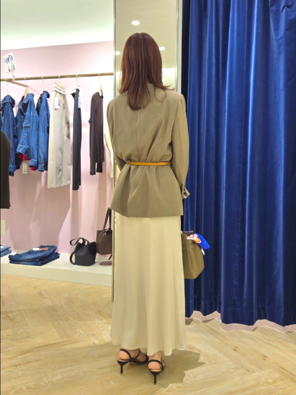 グリーン系のノーカラージャケット、ブラック系のタンクトップ、ベージュ系のトートバッグを着用したレディースの秋コーディネートの5枚目の写真