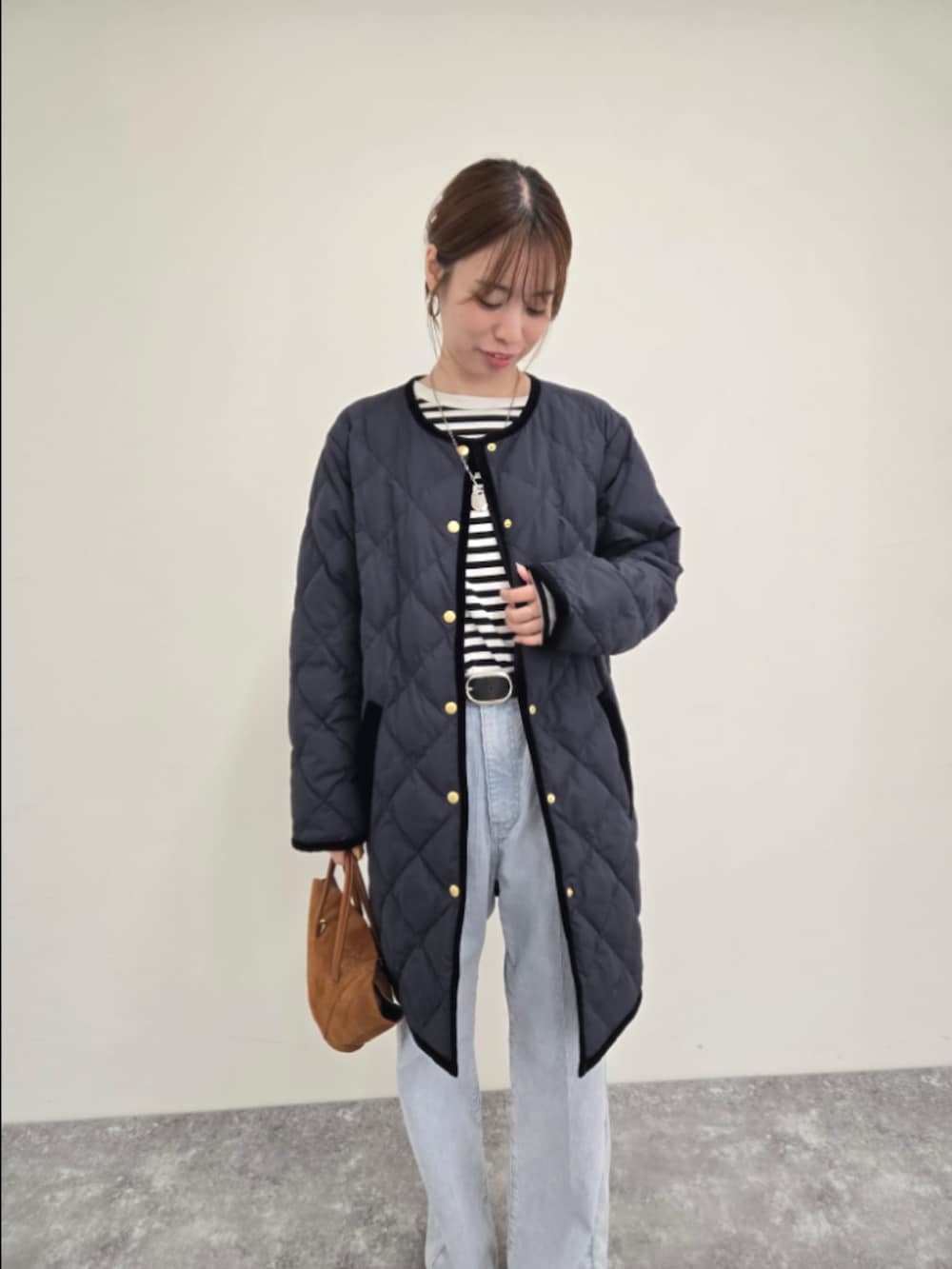 ブルー系のダウンジャケット/コート、ブラック系のTシャツ/カットソー、ブルー系のデニムパンツを着用したレディースの秋コーディネートの5枚目の写真