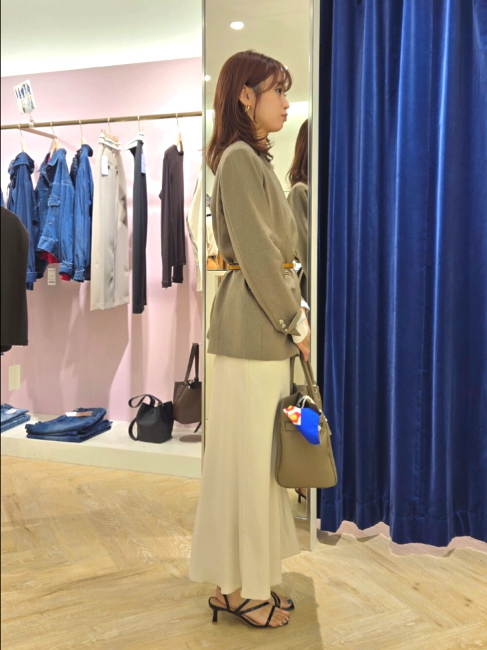 グリーン系のノーカラージャケット、ブラック系のタンクトップ、ベージュ系のトートバッグを着用したレディースの秋コーディネートの4枚目の写真