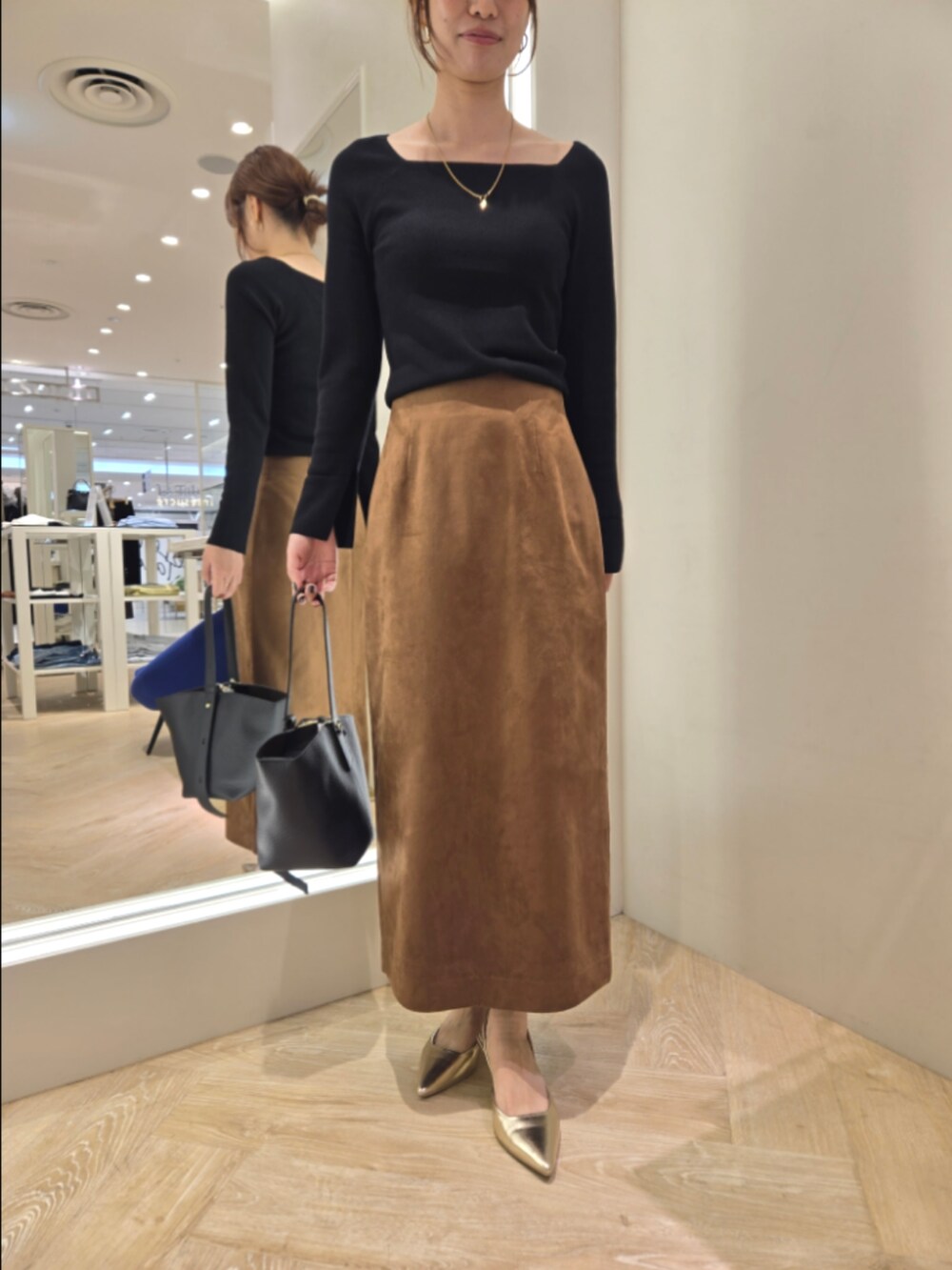 ブラウン系のスカート、ブラック系のニット/セーター、ブラック系のショルダーバッグを着用したレディースの秋コーディネートの8枚目の写真