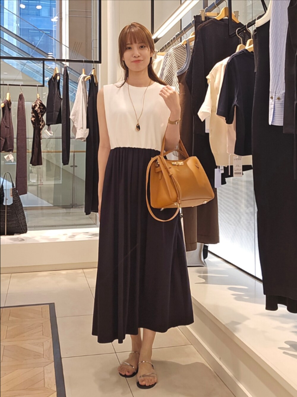 ホワイト系のカーディガン/ボレロ、ブラック系のワンピース、イエロー系のショルダーバッグを着用したレディースの夏コーディネートの4枚目の写真