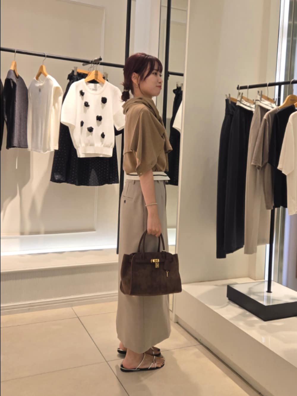 イエロー系のニット/セーター、イエロー系のカーディガン/ボレロ、グリーン系のスカートを着用したレディースの夏コーディネートの4枚目の写真